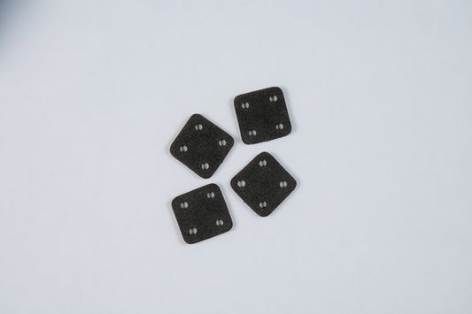 four black square anti-vibration foam pads on a white background
