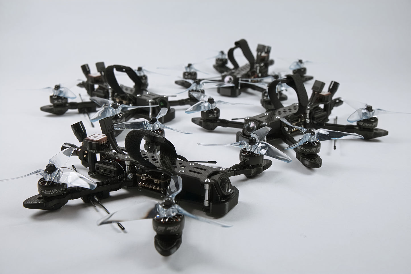 Multiple fpv drones arranged in a pattern with a white background