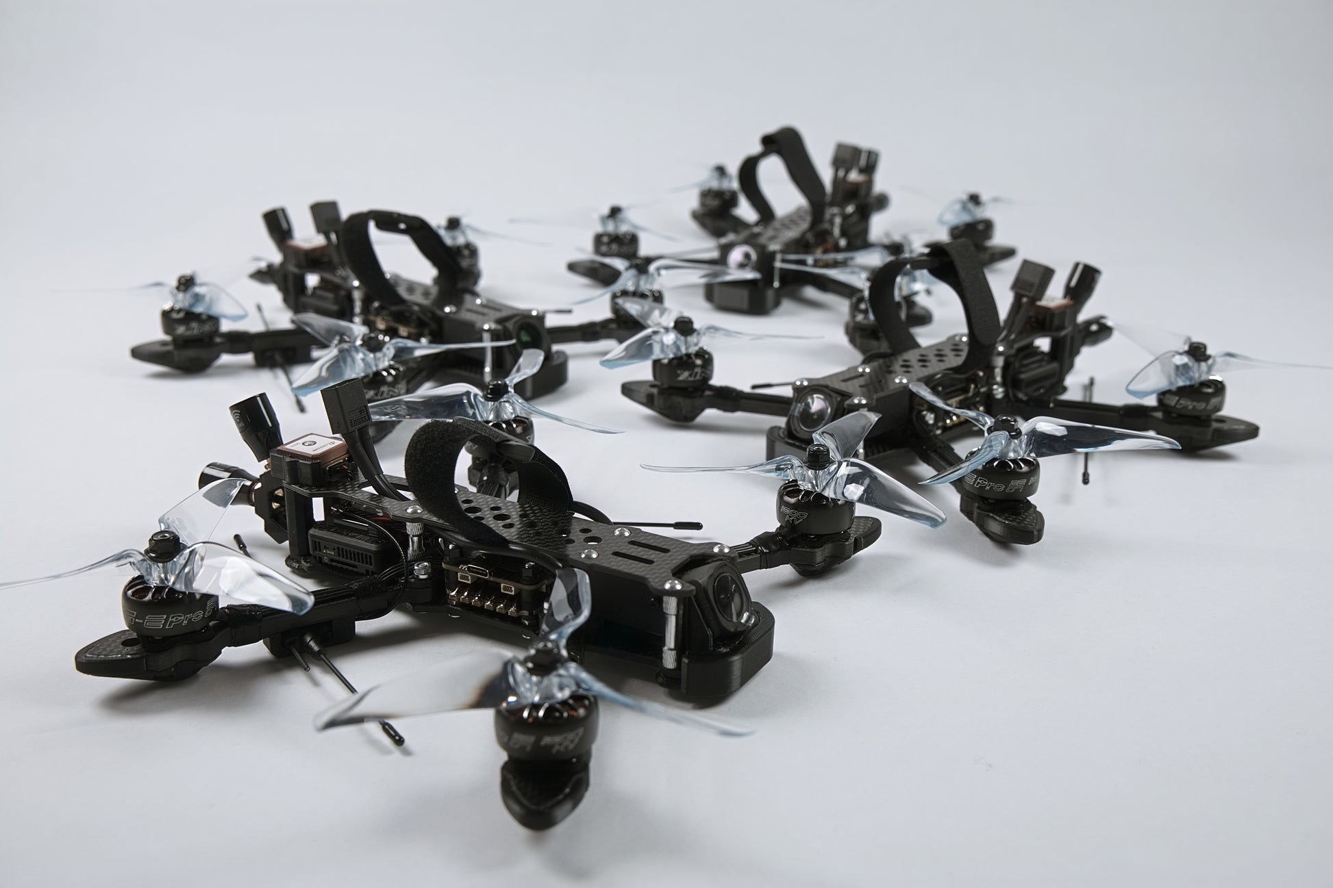 Multiple fpv drones arranged in a pattern with a white background