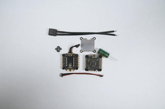 fpv flight stack f722 & (6S) 65amp laid out on a white background