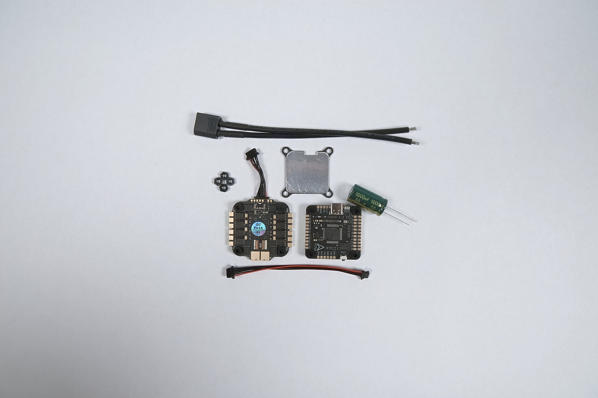 fpv flight stack f722 & (8S) 65amp laid out on a white background