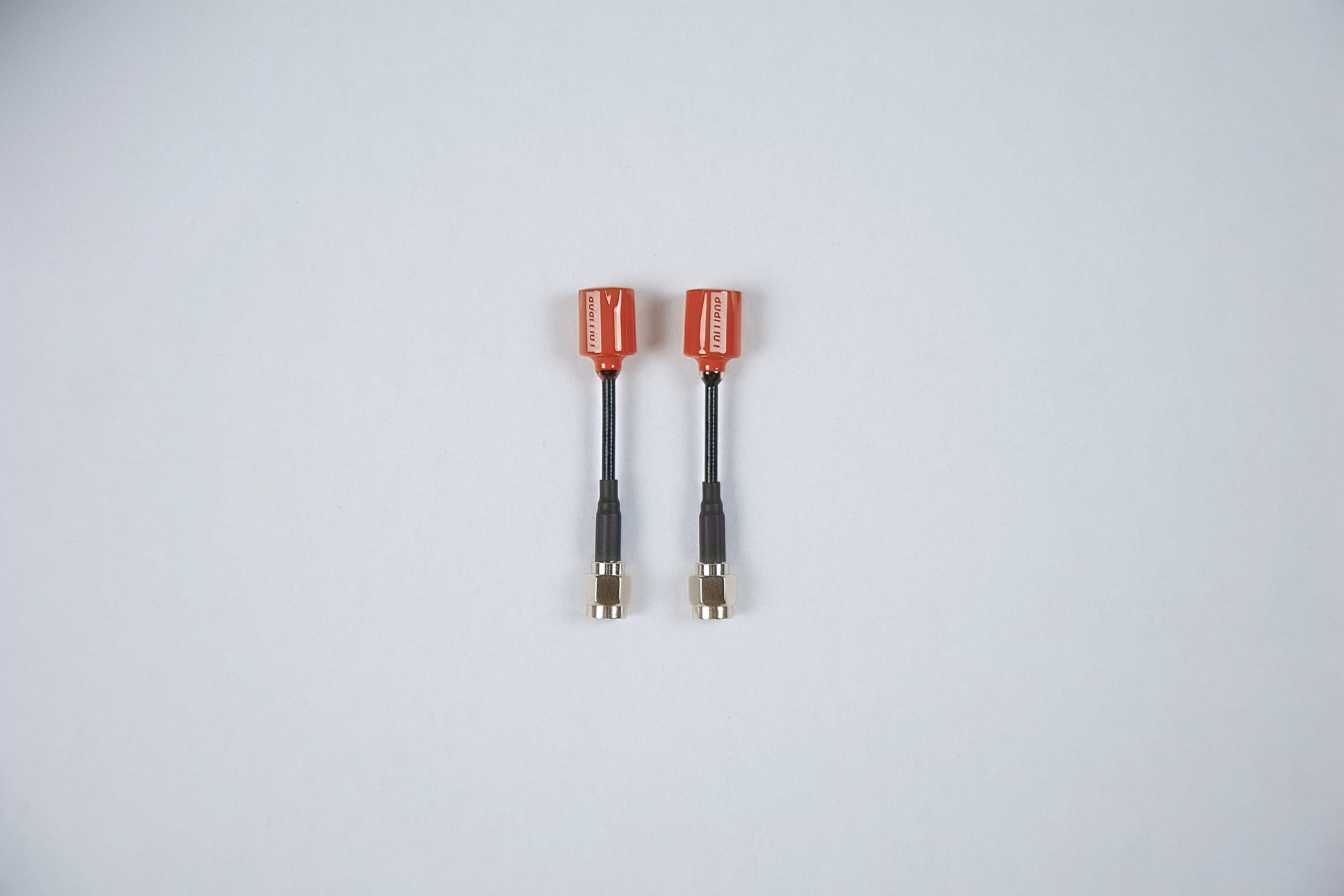 2 red fpv lollipop antennas outside their packaging on a white background 